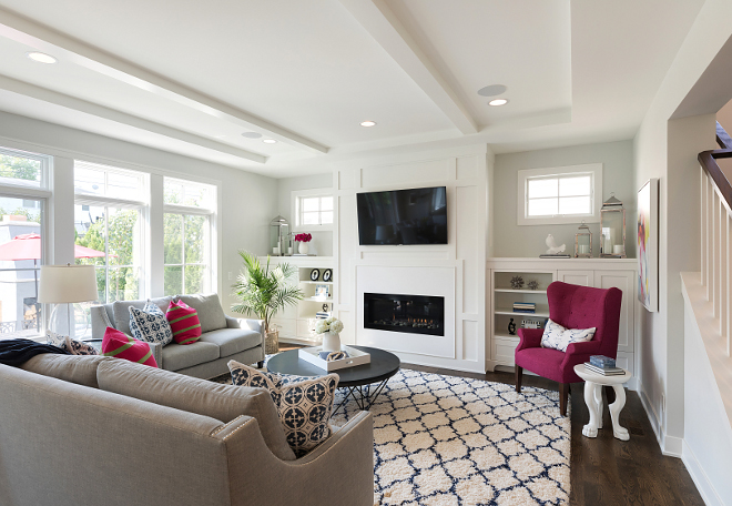 Living room with grey walls and white media cabinet flanking fireplace This living room features grey walls and white media cabinet flanking a fireplace with white paneling