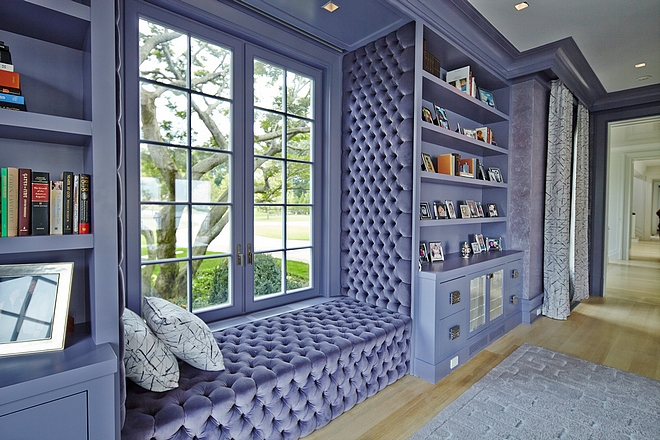 Purple Library Cabinets with tufted window-seat flanked by custom bookcases