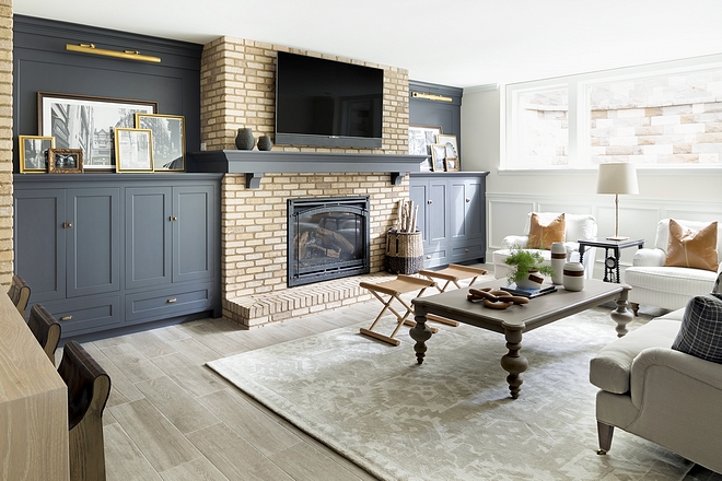 Basement Brick Fireplace flanked by navy built ins