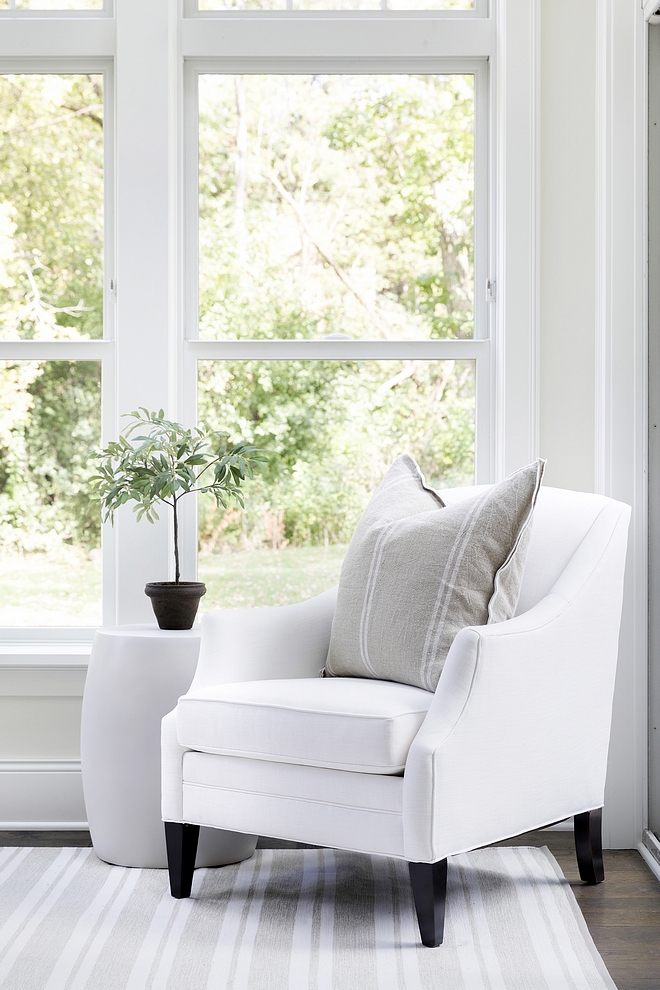 white accent chair with farmhouse pillow and white and grey striped rug