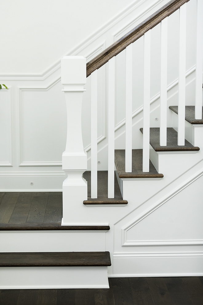 Curved custom newel post The staircase features curved custom newel post, wainscoting and dark stained stair treads #curvednewelpost