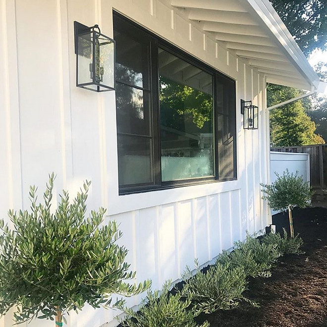 Black Windows with black exterior sconces and board and batten siding