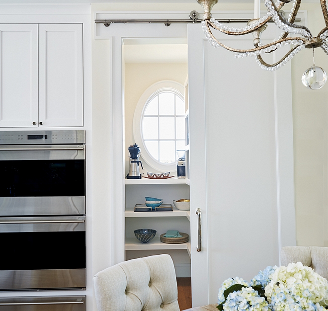 Pantry door A white door, hung with barn door hardware, conceals the kitchen pantry #pantry #pantrydoor