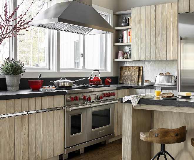 Range by window In her quest to create visual sight lines in this kitchen, the deisgner suggested placing the range and vent hood in front of the windows, instead of the sink