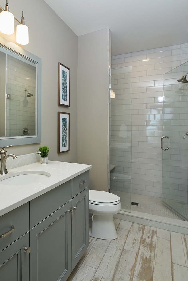 Arctic Gray by Benjamin Moore grey bathroom with distressed wood-looking tile Arctic Gray by Benjamin Moore grey walls and distressed wood-looking tile Cabinet paint color is Benjamin Moore Gray Pinstripe 1588 #BenjaminMoore #Benjaminmoorepaintcolors