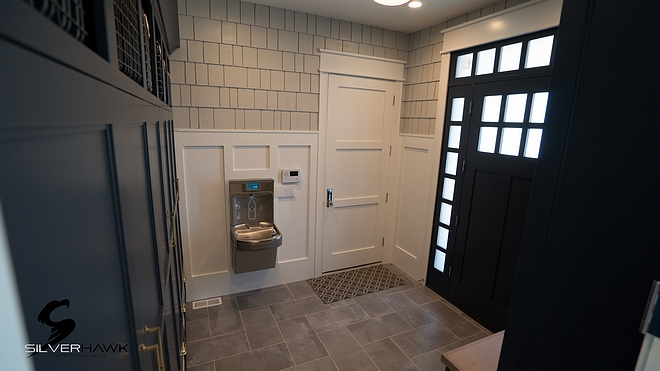 Mudroom This mudroom features built-in lockers, dog kennel and navy cabinetry Mudroom Mudroom with board and batten paneling