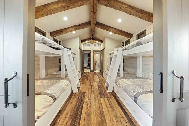 Farmhouse Bunk Room with four bunk beds reclaimed hardwood floors and reclaimed Timber beams #farmhouse #farmhousebunkroom #farmhousebunkbeds #bunkroom #reclaimedhardwoodfloor #reclaimedtimber #timberceiling #reclaimedhardwood #reclaimedwood