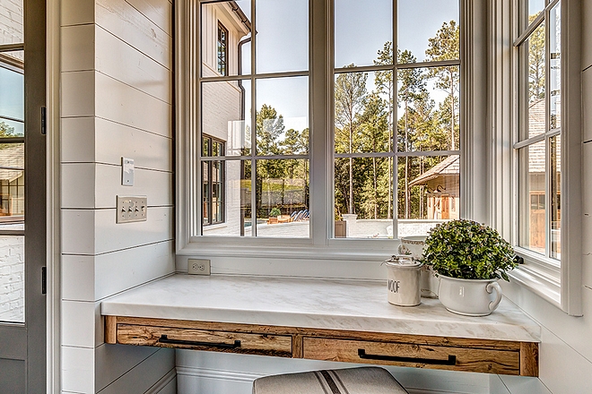 Floating Desk Drop zone with floating desk Mudroom drop zone with reclaimed White Oak floating desk with white marble countertop and shiplap walls windows looking towards backyard #floatingdesk #dropzone #mudroom #desk #whiteoak #reclaimedwood