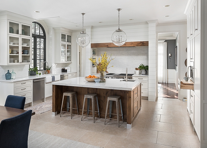 Kitchen Renovation We opened up the wall on either side of the range to create two entrances to the dining room and flood the kitchen with it’s beautiful light Gorgeous cabinetry is more streamlined and functional and includes a deeper island in a custom wood-stain to warm up all the space #kitchenrenovation #kitchen #renovation