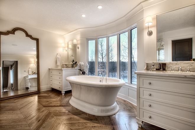 French Bathroom French Bathroom Design French Master Bathroom with paneled walls inset mirrors free standing tub and chevron hardwood flooring #Frenchbathroom #bathroom #chevronflooring