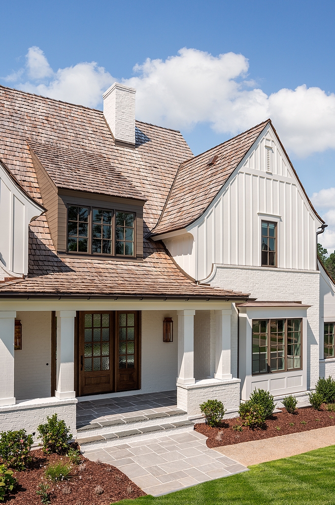 Modern Farmhouse exterior with classic elements such as Painted Brick Board and Batten Siding Cedar Shake Roofing and painted windows sources on Home Bunch #modernfarmhouse #farmhouse #exteriors #paintedbrick #boardandbatten