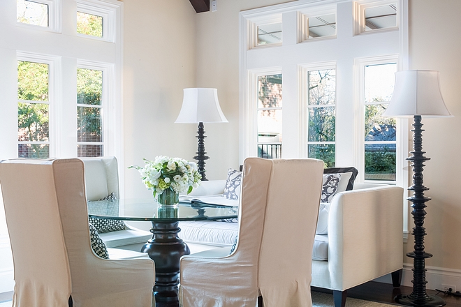 Breakfast Room with round table slipcovered dining chairs floor to ceiling windows settee and Noir floor lamps #breakfastroom