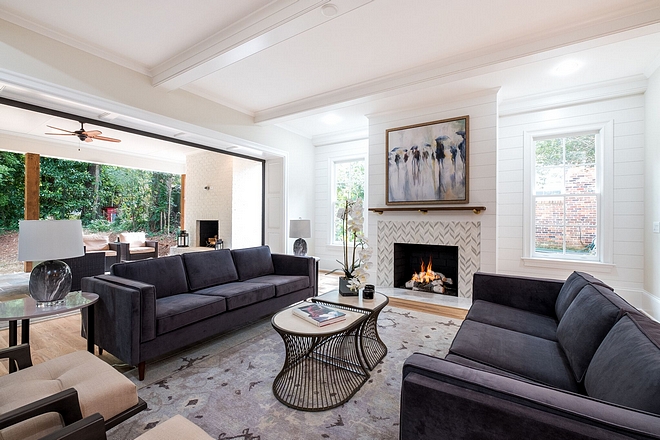 The living room features custom Beams in ceiling and shiplap accent wall flanking fireplace