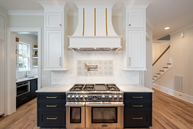 Kitchen features Honed Marble backsplash with custom picture frame above stove
