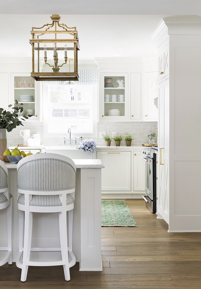 Small White Kitchen Small white kitchen with pale grey backsplash tile brass lighting and wide plank hardwood floor floor #smallkitchen #smallwhitekitchen #whitekitchen #smallkitchens