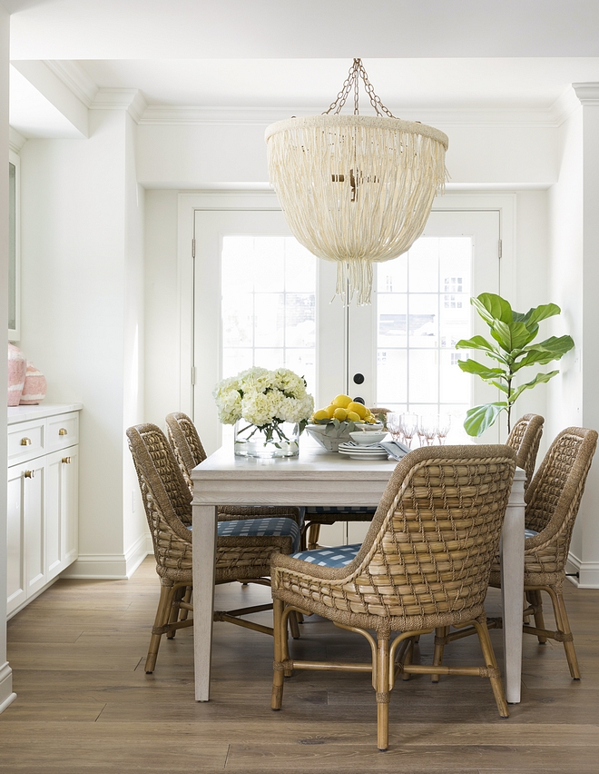 Coastal Relaxed Dining Room with Rattan Dining Chairs Pole rattan frame and legs in natural seagrass tied with lampakanai rope and wide plank hardwood floors Palecek Capitola Arm Chair All sources on Home Bunch #diningroom #coastalliving #Coastalinteriors #coastalhomes #coastaldiningroom