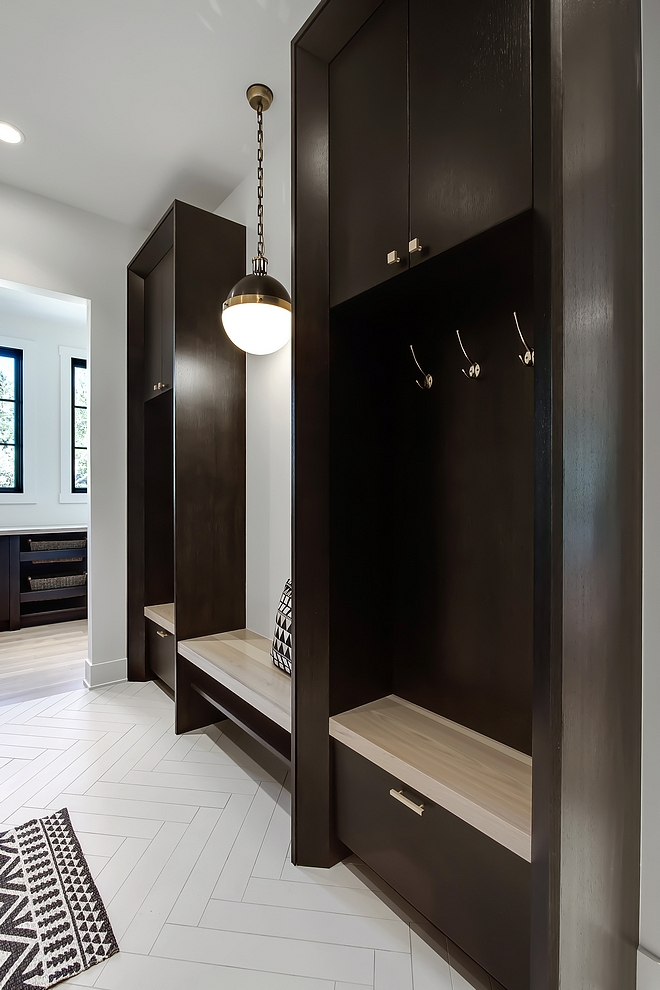 Mudroom The main level mudroom features custom built-on-site 1⁄4 sawn oak lockers and shelves for shoe storage. Flooring is an oversized porcelain tile in a herringbone pattern #mudroom #mudroomlockers #mudroomflooring