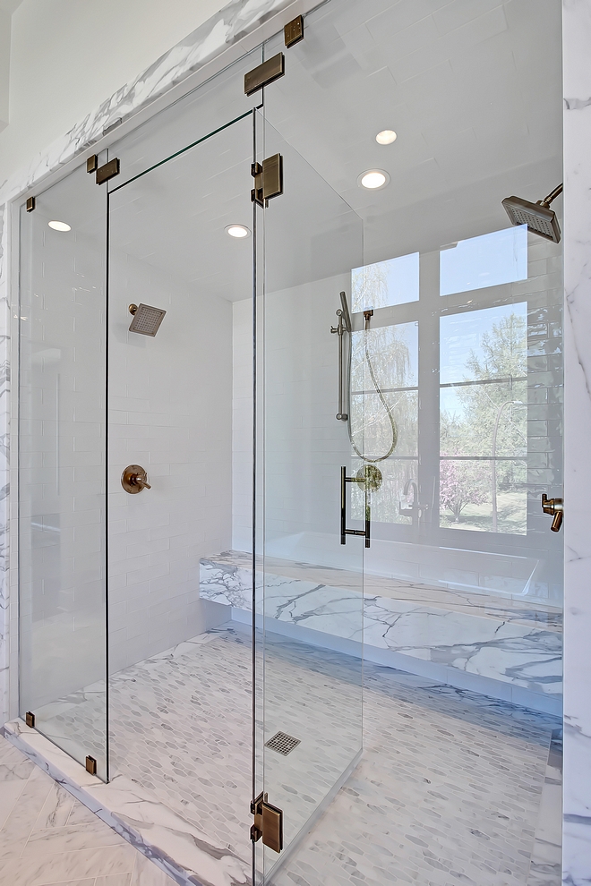 Shower Tile Master Bathroom shower tile The master bathroom shower features 3x12 Cotswold white tile for walls and ceiling (steam unit), solid Statuario marble bench, Carrara long octagon mosaic for the shower base #masterbathroom #showertile