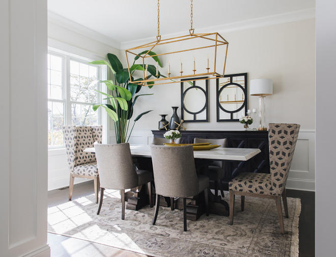 Dining Room Decor The dining room wainscoting gives it a classically formal feel but the gilded iron linear light fixture makes it fresh and inviting #diningroom #decor #diningroomdecor