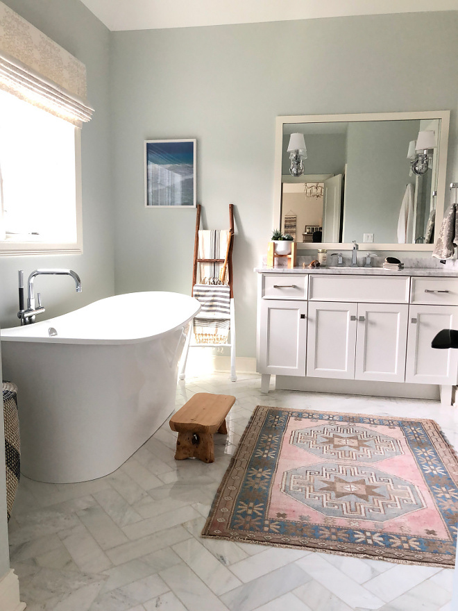 Bathroom with white marble herringbone floor tile soothing and blue grey walls All sources and paint colors on Home Bunch #bathroom #whitemarbleherringbone #herringnonetile #floortile