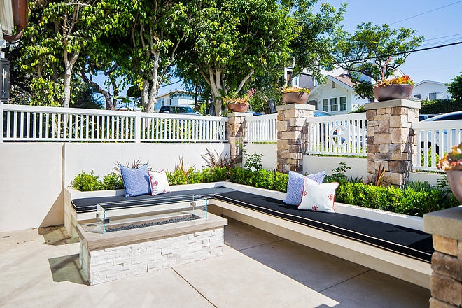 This inviting courtyard features a custom floating bench against flower beds Flooring is acid washed concrete #courtyard #outdoorbench #floatingbench