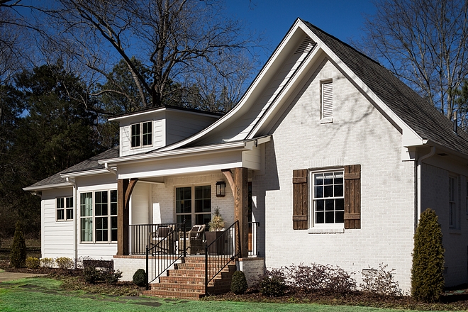 Small Farmhouse exterior renovation Brick Exterior was painted in Sherwin Williams Oyster White Windows are wood, painted in an exterior almond paint color Wood shutters and timber columns add to the curb-appeal of this home Small Farmhouse exterior renovation #Farmhouseexteriorrenovation