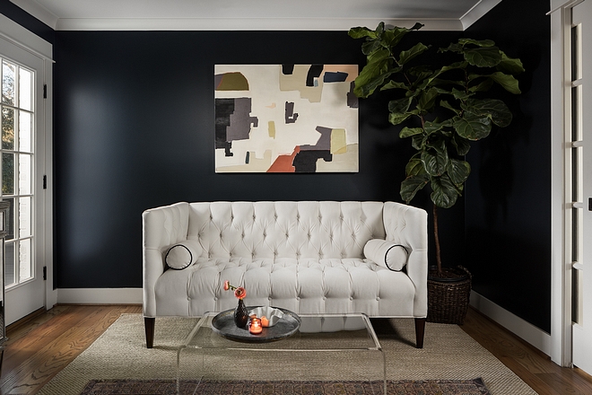Painted in Blue Black by Farrow and Ball, the living room feels dramatic and elegant at the same time