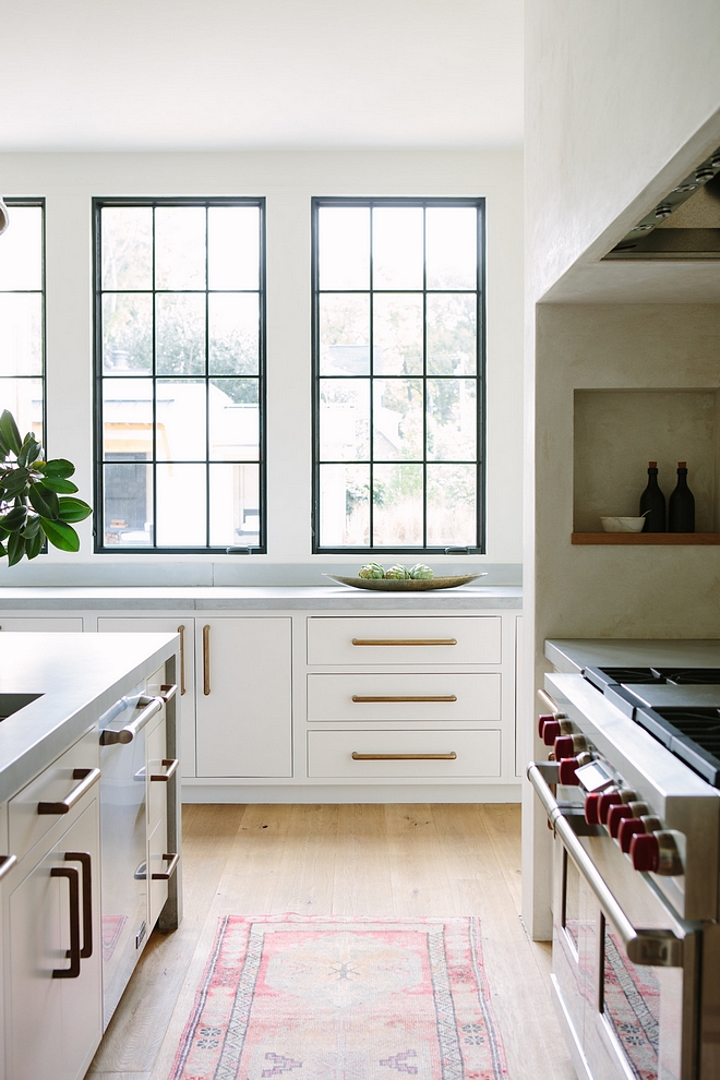 White Kitchen Minimalist White Kitchen with white cabinetry painted in White Dove by Benjamin Moore, black windows and concrete countertop #minimalistkitchen #WhiteDovebyBenjaminMoore #blackwindows #concretecountertop