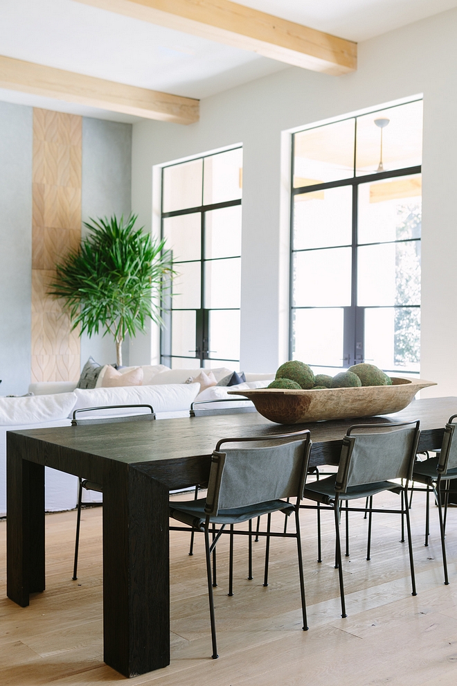 The dining room carries the same clean-lined feel Metal and leather dining chairs complement a black dining table with chunky legs