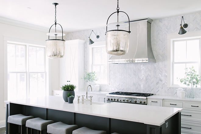 Kitchen features white perimeter cabinets, charcoal gray island , beautiful pendant light and chevron backsplash tile #kitchen #whitekitchen #kitchenpendantlight #countertop #charcoalisland #chevronbacksplash