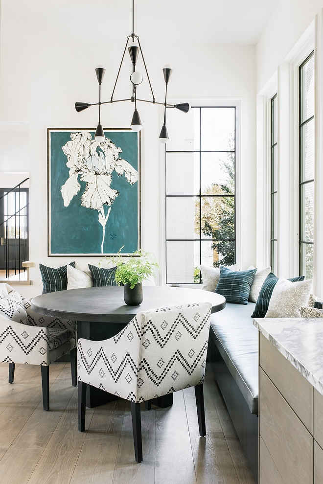 Modern Breakfast Nook with black framed windows, modern chandelier and a large l-shape banquette #BreakfastNook #ModernInteriors #Modernhomes #Modernchandelier #banquette