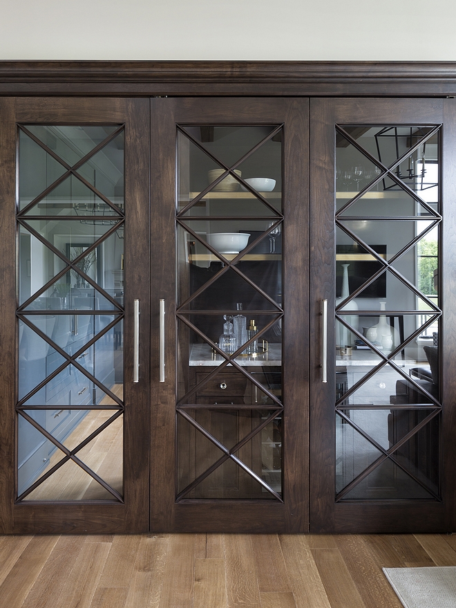 Walnut Glass Inset Doors Custom Walnut doors with glass X insets conceal the butler's pantry and a wet bar