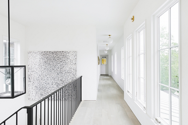 Landing Area Windows and metal railing On the second floor, the wood flooring and plaster walls continue but also meets wide plank shiplap - creating a welcoming sense of cohesion and style #LandingArea #Windows