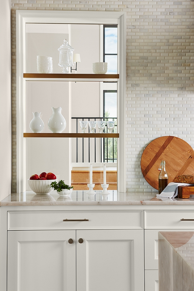 This kitchen is full of inspiring ideas To keep a sense of symmetry, the designer added a glass opening to the wall with brass floating shelves #kithen #kitchenshelves #brasshelves