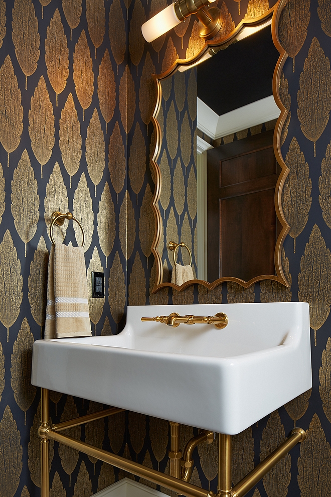 Located just off the mudroom, this powder room is elegant and features a gorgeous wallpaper, curved brass mirror and a brass base washstand #bathroom
