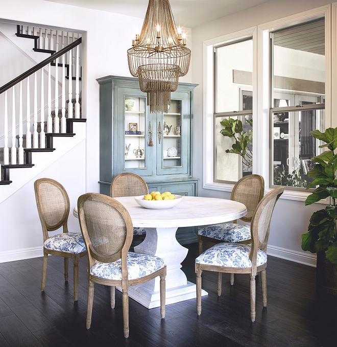 Breakfast room with round dining table, classic caned back dining chairs and a beautiful chain chandelier. Robin egg blue hutch is vintage #breakfastroom #rounddiningtable #diningchairs #Robineggblue