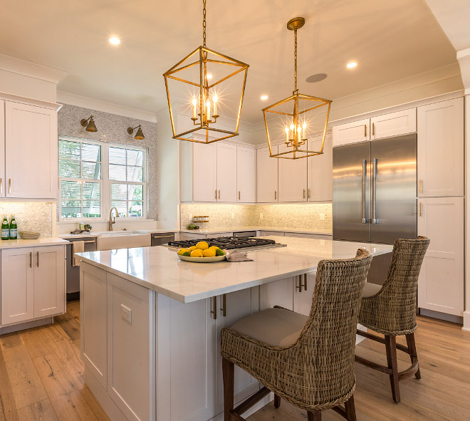 Kitchen Island with marble-looking countertop, hardwood flooring, stainless steel appliances and brass pendant lighting #kitchen #kitchenisland #brasspendantlighting #hardwoodflooring #marblelookingquartz #countertop