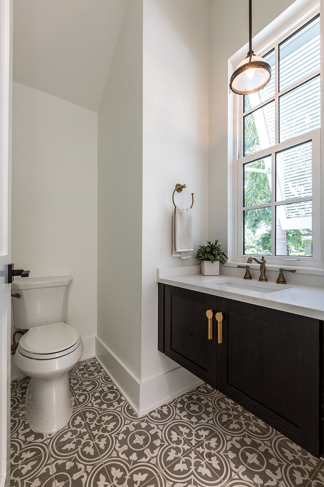 The powder room features a floating vanity with quartz countertop and grey and white cement tile #powderroom #floatingvanity #cementtile