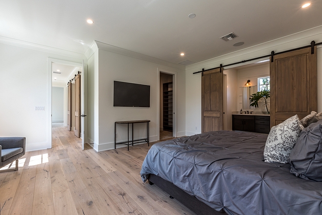 Modern farmhouse master bedroom with barn door to master bathroom