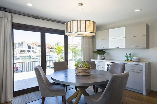 This breakfast room has a great view of the canal and it features a custom bar cabinet with 2.5” Superwhite Quartzite mitered waterfall edge