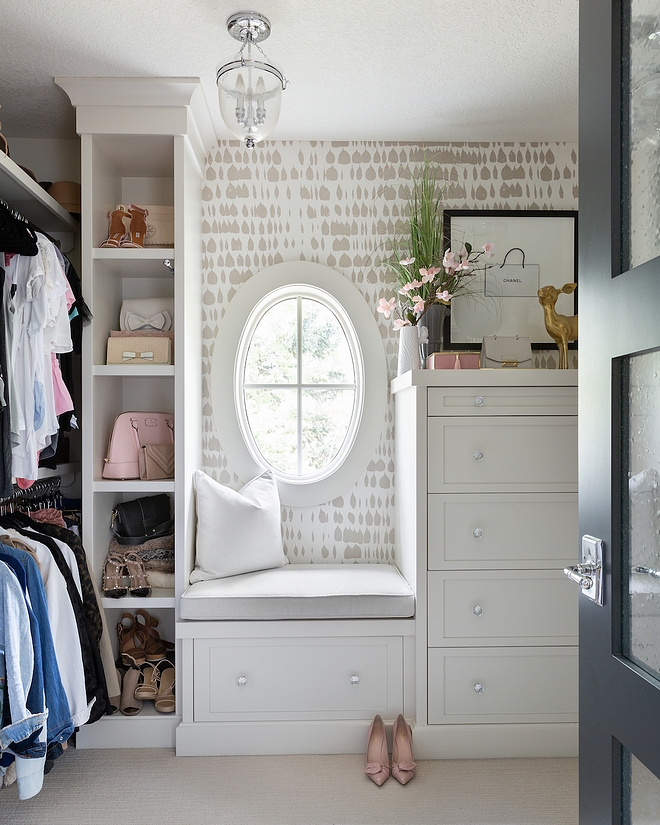 Her Closet The closet has lots of built-in shelving and a full dresser with jewelry drawers The oval shaped window lets in plenty natural light, which helps this space feel clean and airy #closet #hercloset #walkincloset #dressingroom
