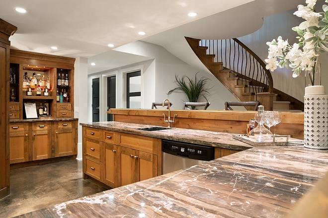 My husband has a large scotch collection as well, which we keep outside the wine room in a back-lit mirrored shelving area. The bar is outstanding for entertaining and storage, with a built in TV and our own house cocktail menu for guests to choose from