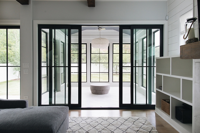 The family room opens to a spacious sunroom with black steel doors and windows #sunroom #blacksteeldoors #blacksteelwindows