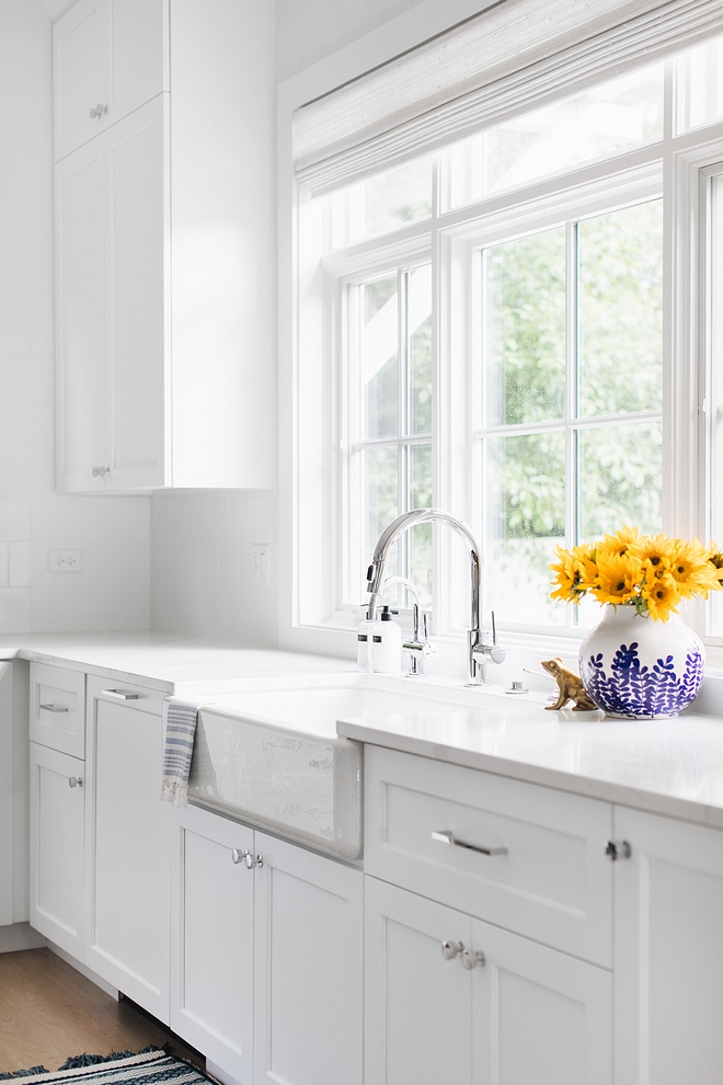 White kitchen painted in Extra White by Sherwin Williams with marble quartz countertop, fireclay farmhouse sink and an arched kicthen faucet #kicthen #kitchen #ExtraWhitebySherwinWilliams