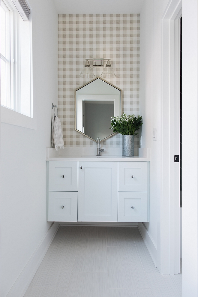 The kids' bathroom feature custom floating vanity and a gingham wallpaper. Countertop is Snow White quartz and the vanity paint color is SW Extra White