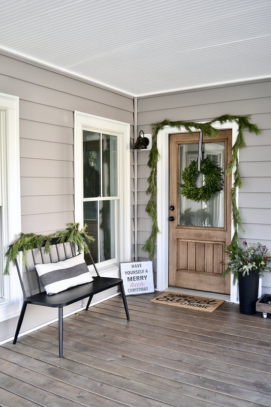 Farmhouse Porch Christmas Decor Farmhouse Porch Christmas Decor with Black spindle bench and garland and wreath on front door Farmhouse Porch Christmas Decor #FarmhousePorch #PorchChristmasDecor