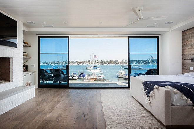 Beach house bedroom balcony The fireplace features painted brick #beachhouse #bedroom