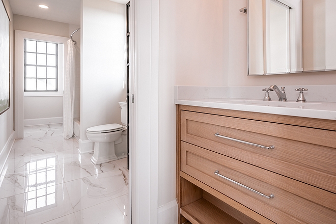 The Jack and Jill bathroom features Rift-Cut White Oak cabinetry with inset drawers, Rift-Cut White Oak Frost Rift-Cut White Oak cabinetry #RiftCutOak #WhiteOak #cabinetry