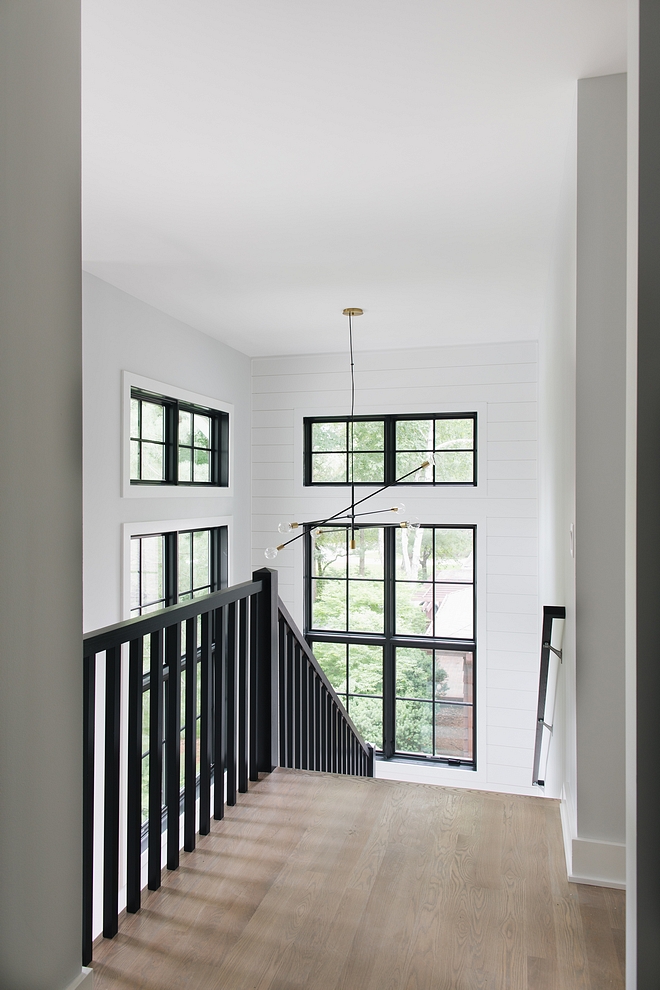 Modern Farmhouse Stairway The combination of black railings, black windows, a modern black and brass chandelier with white shiplap really brings this entire space to the next level. Impressive, dramatic yet neutral #modernfarmhouse #stairway #staircase