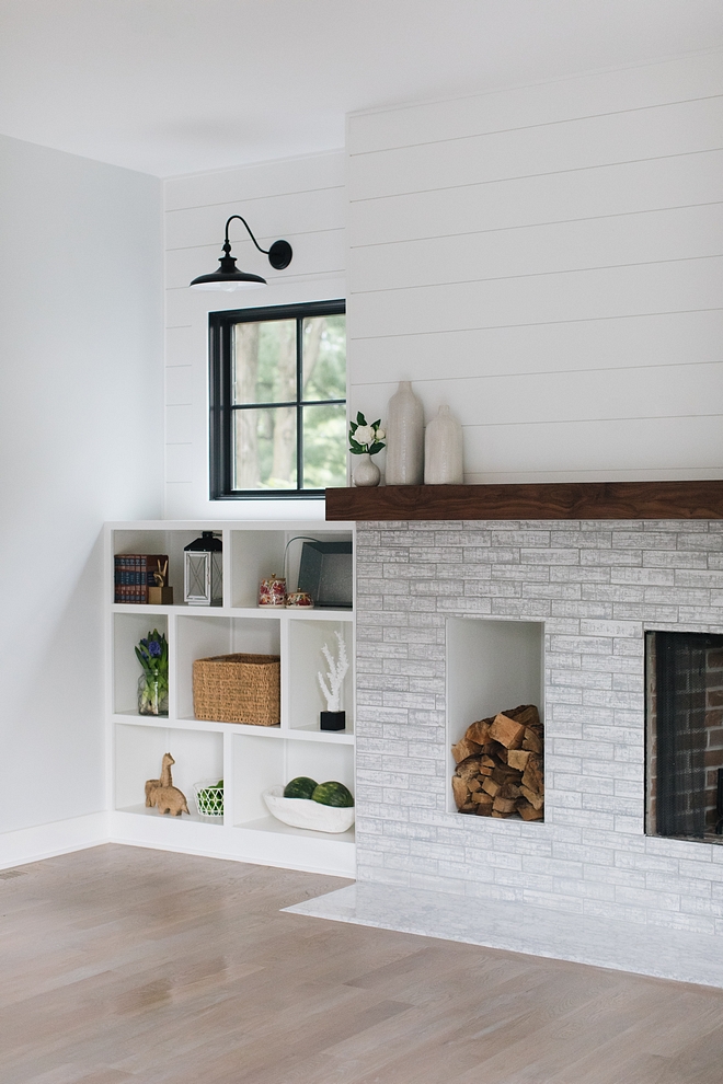 Modern farmhouse Fireplace This modern farmhouse fireplace features a brick-style tile and a dedicated wood storage space Mantel is made of Walnut